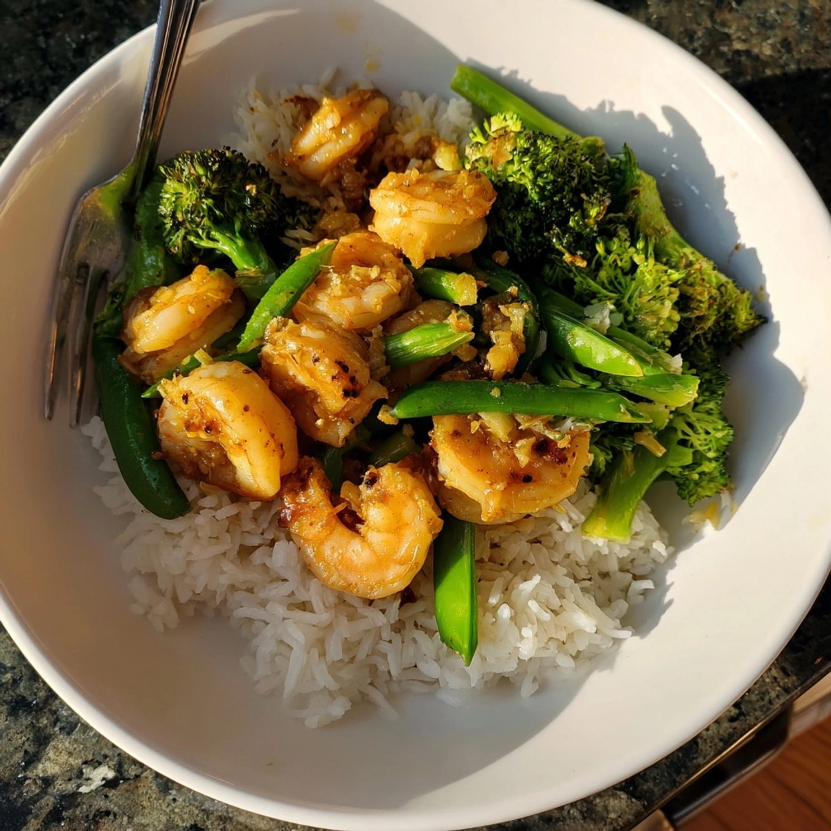 Garlic butter shrimp stir-fry: glistening shrimp with bright veggies over fluffy rice.