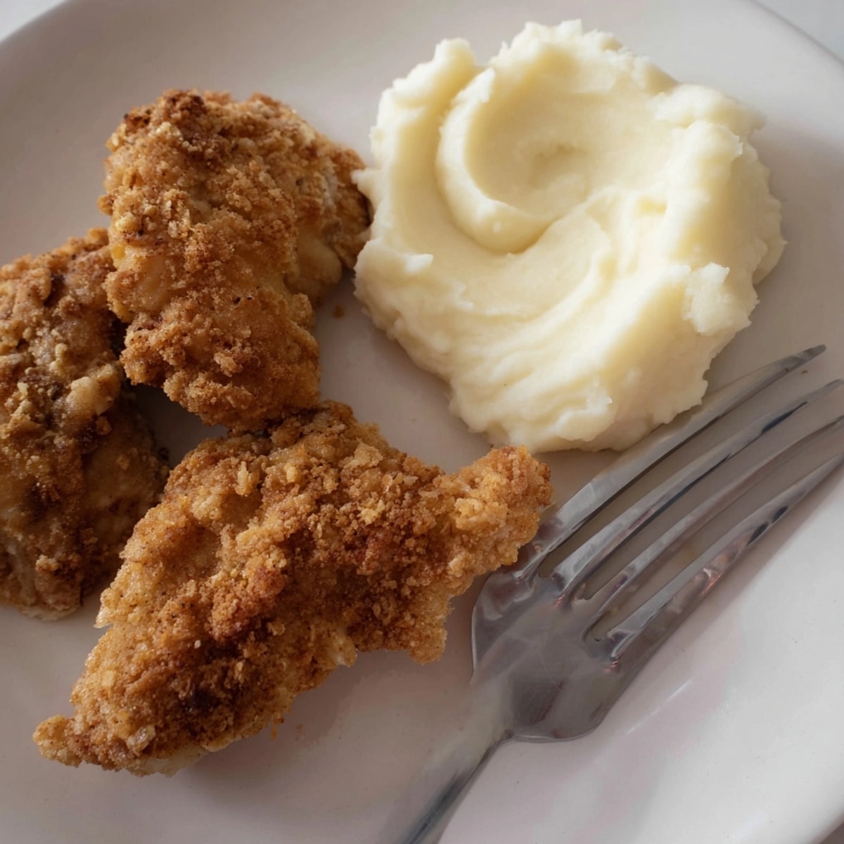 Crispy Parmesan Chicken: golden, cheesy crust sizzling, served over creamy mashed potatoes.