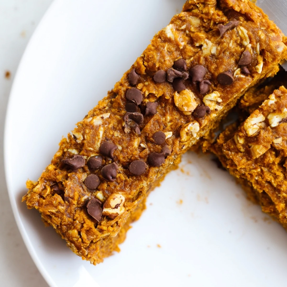 Warmly spiced pumpkin protein bars served with a drizzle of maple syrup.