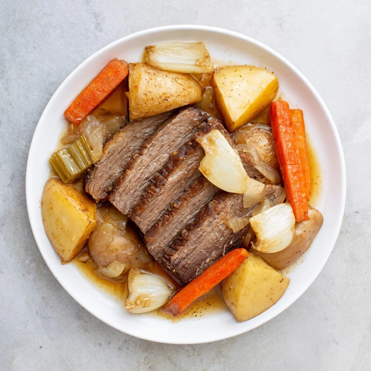 This savory photo shows a tender Sunday Pot Roast with roasted carrots and potatoes glistening.