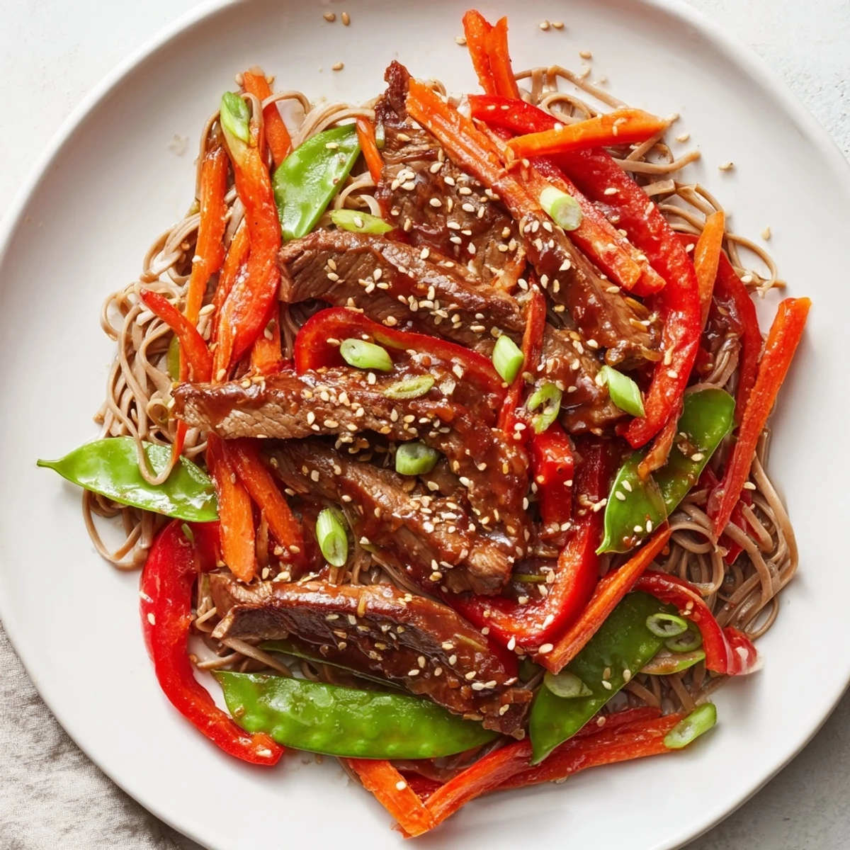 Steaming Teriyaki Beef & Noodle Bowl with glistening sauce, sesame seeds, and fresh green onions, ready to eat.