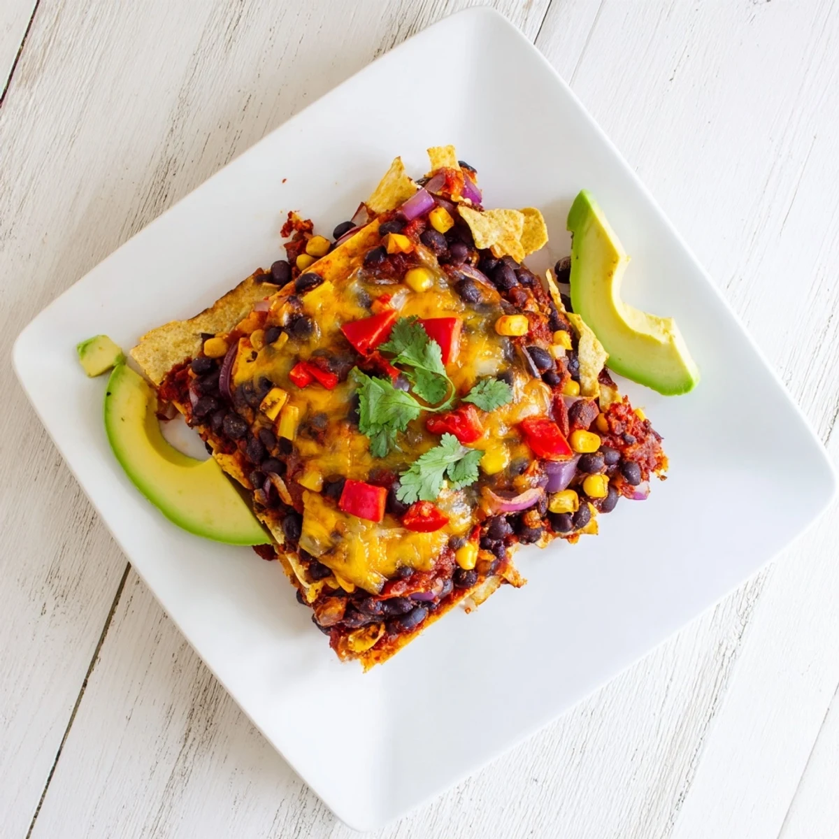 Golden-topped Quick Black Bean and Corn Tortilla Casserole, a delicious vegetarian meal served with fresh cilantro.