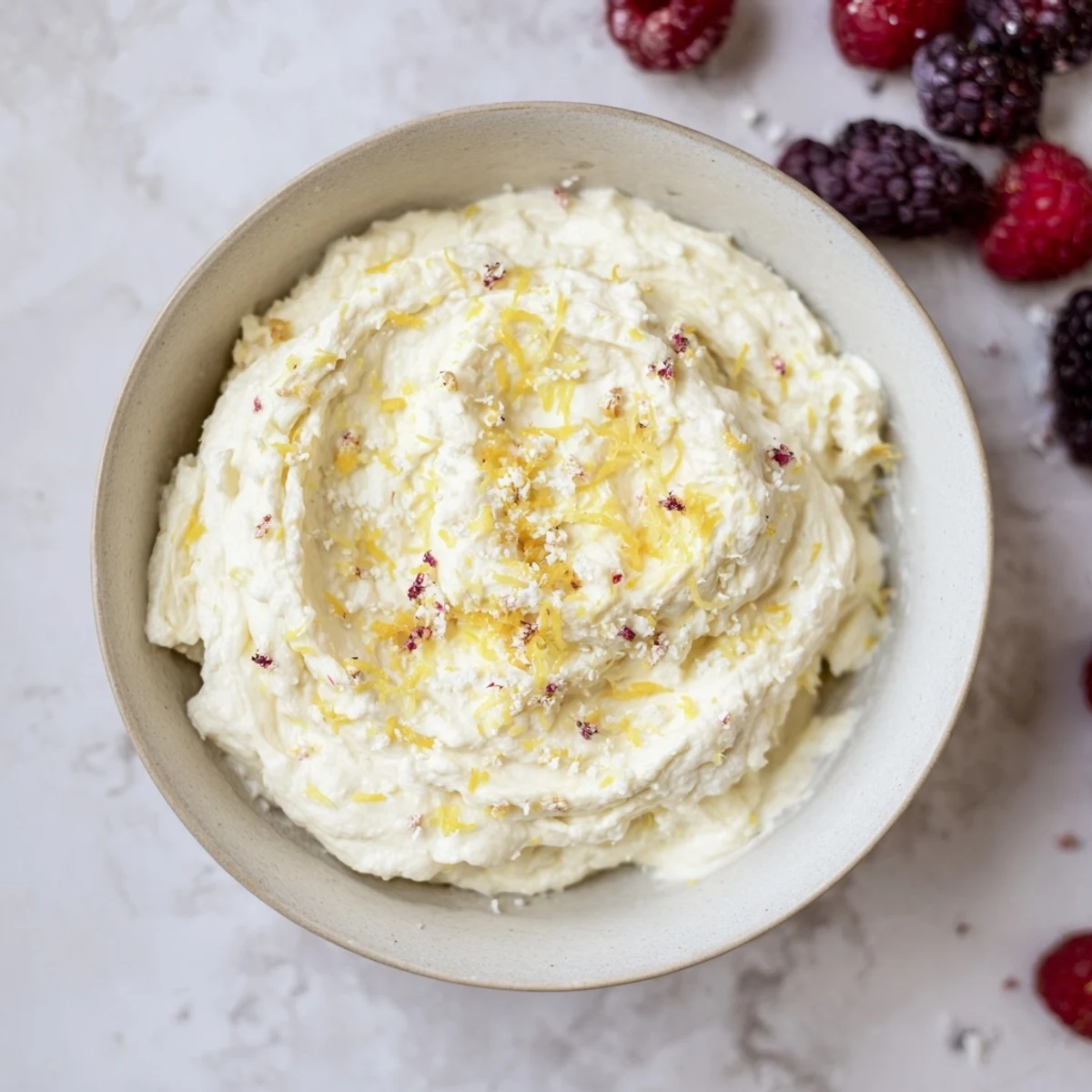 Fluffy Cream Cheese Fruit Dip, overflowing with fresh berries--a creamy, sweet, and tangy treat.
