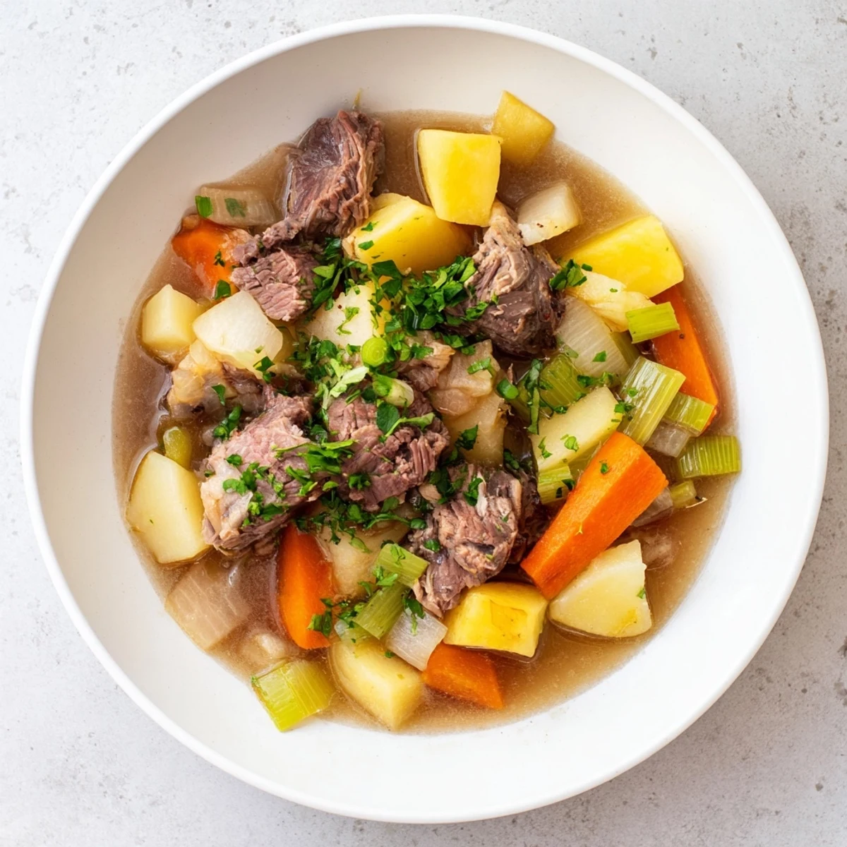 Hearty Welsh Cawl stew, with tender lamb and root vegetables in a flavorful broth, perfect for a chilly evening.