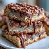 Chewy, festive cookie bars loaded with chocolate chips and candy-coated chocolates, topped with a glossy white chocolate drizzle for a sweet finish.  