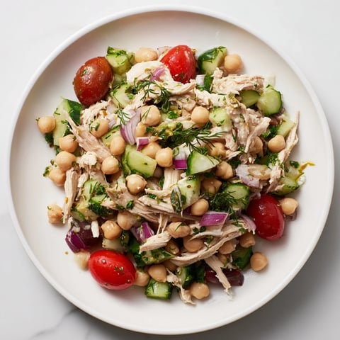 Dense Bean Salad featuring bright vegetables and shredded chicken bathed in lemon-dill dressing.