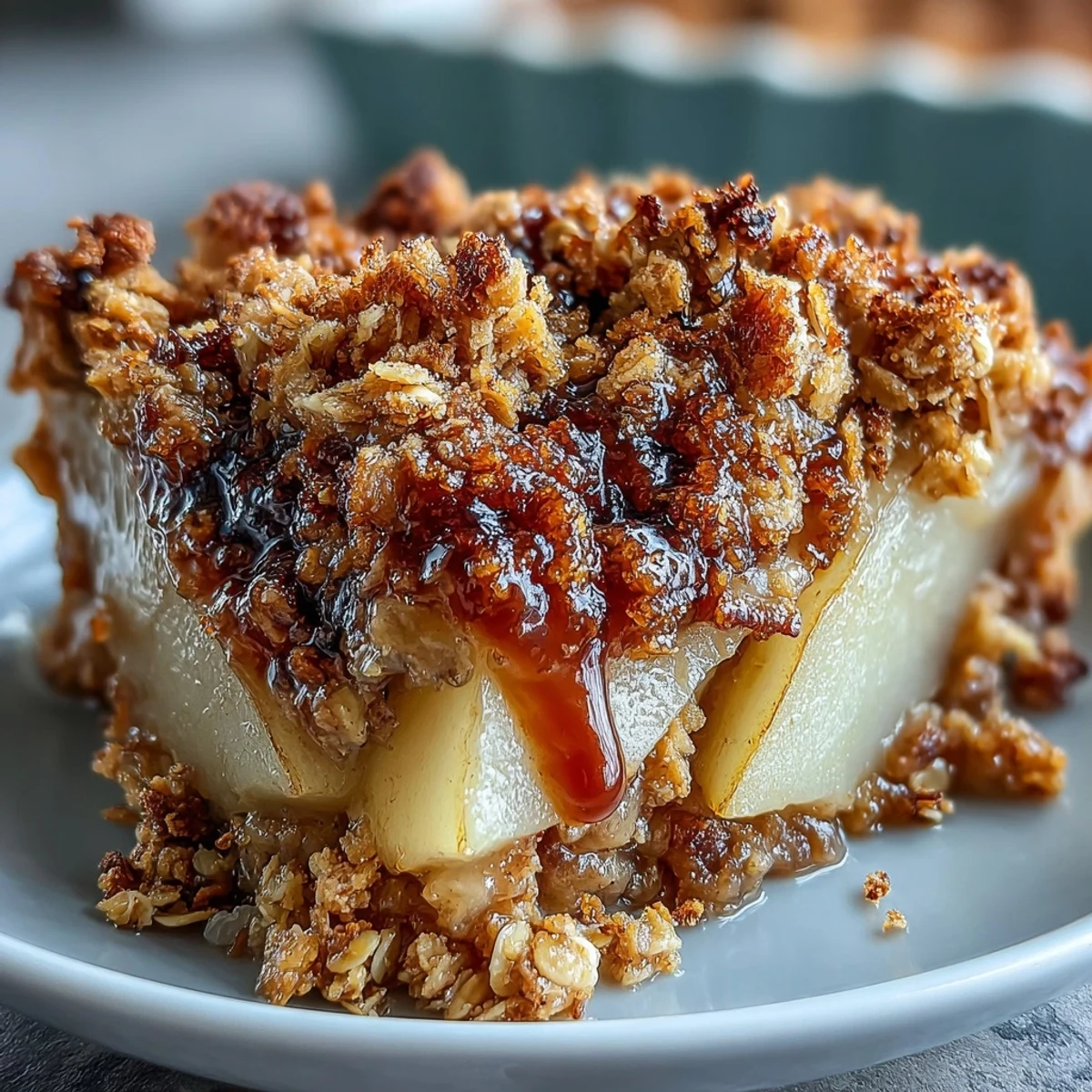 Freshly baked Pear Crumble with a golden oat topping, bubbling with sweet cinnamon-spiced pear slices in a rustic dish.