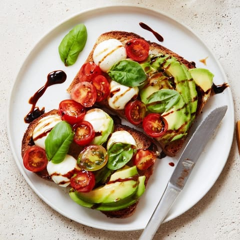 Delicious Caprese Avocado Toast recipe, drizzled with balsamic; a perfect light lunch option.