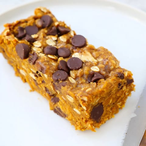 Decadent pumpkin muffin protein bars topped with walnuts and chocolate chips.  