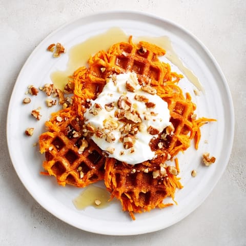 A beautiful stack of Sweet Potato Waffle Hack, described by its fluffy texture and inviting cinnamon scent.
