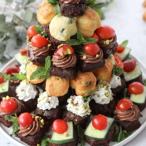 A delightful Tour dÉléphant Goûter Gourmand snack tower with honey drizzle and fresh mint garnishes.