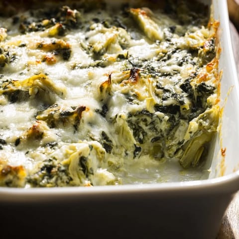 Creamy and delicious Cheesy Spinach Artichoke Dip, served with crispy tortilla chips for dipping.