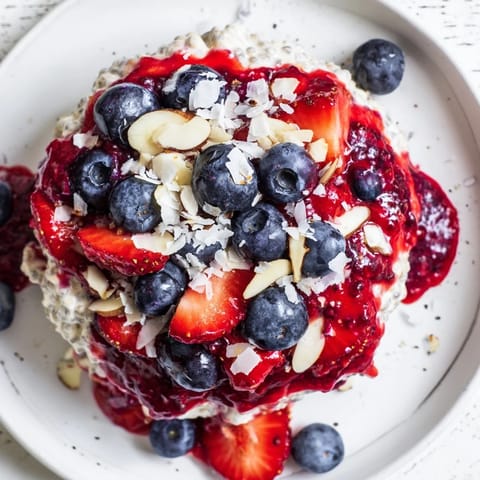 A close-up of berry chia pudding, showing the layered texture with fresh berry topping.