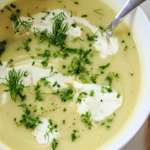 A velvety parsnip and herb soup served with crusty bread on a wooden table, steam rising.