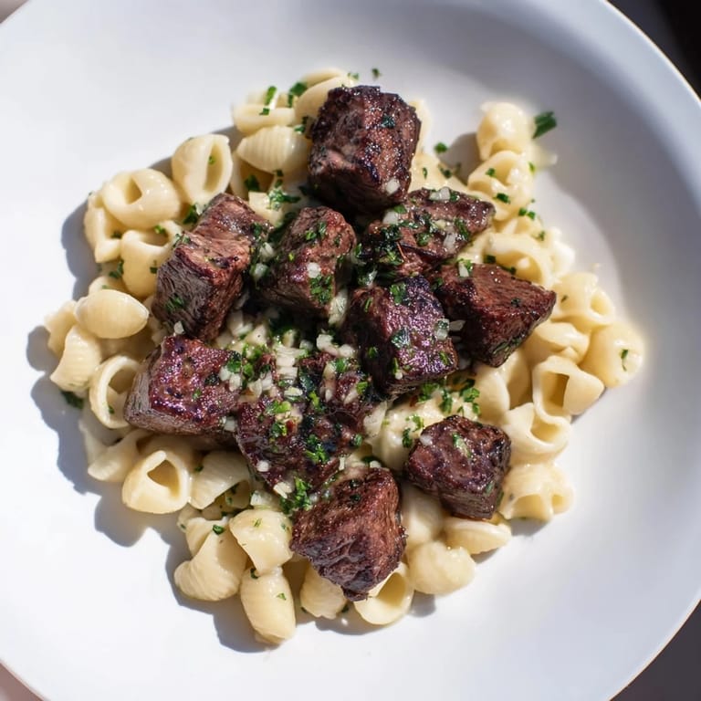 Perfectly browned garlic butter steak bites with cheesy shells, a comforting American dinner recipe.