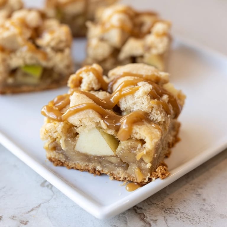 Warm, inviting photo of freshly baked caramel apple cookie bars, brimming with gooey caramel.