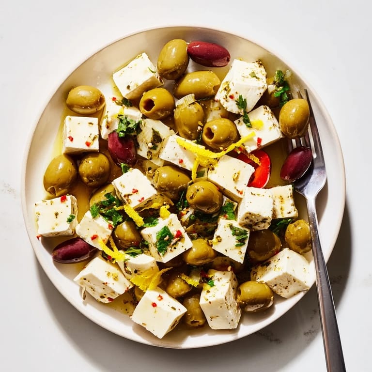 Mediterranean Holiday Mix appetizer: a close-up of olives, feta, and fresh herbs, ready for serving.