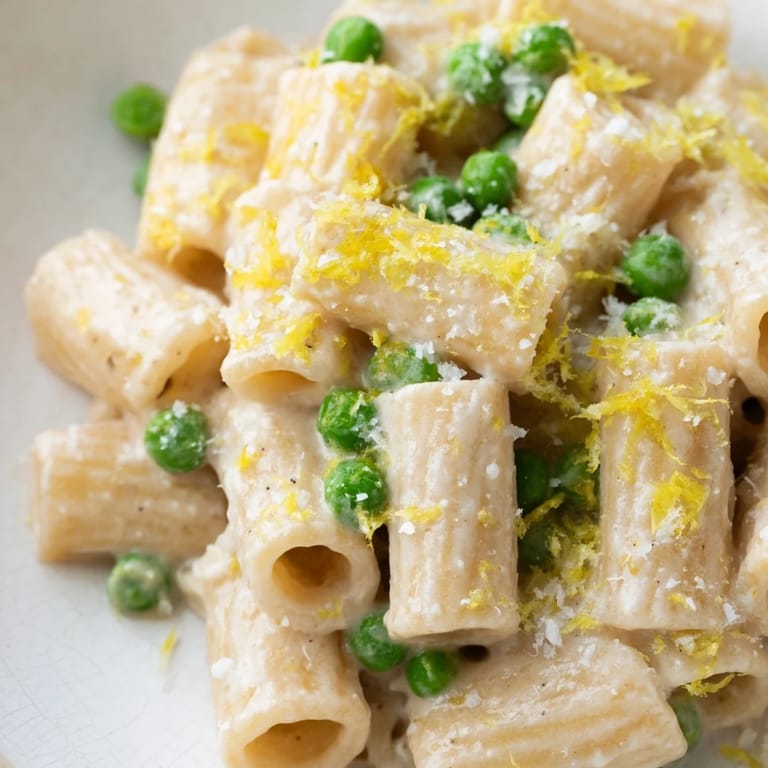 Vibrant spring pasta with peas and ricotta, served warm with a squeeze of lemon and fresh herbs.