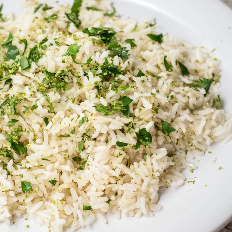 A serving bowl of aromatic Cilantro Lime Rice topped with extra cilantro and a lime wedge, ready to pair with tacos.